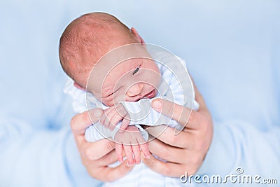 Cute tiny newborn baby boy in his father's hands Stock Photo