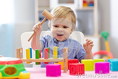 Cute toddler baby playing with wooden hammer block toy Stock Photo