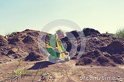 Cute toddler boy with plastic shovel and plush fox toy wearing green and yellow Stock Photo