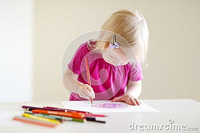 Cute toddler girl drawing with colorful pencils Stock Photo