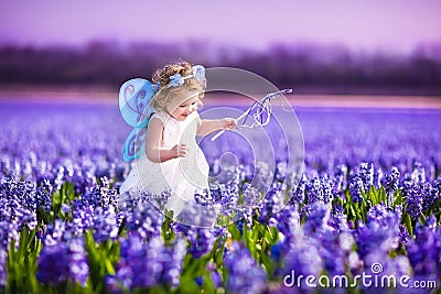 Cute toddler girl in fairy costume in a flower field Stock Photo