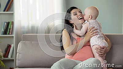 Cute toddler girl kissing and hugging her mother, love and tenderness in family Stock Photo