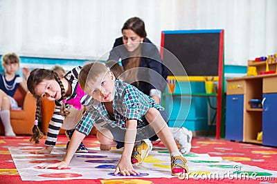 Cute toddlers playing in twister game Stock Photo