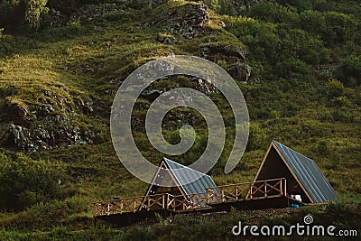 Cute triangle houses on a background of green grass of high mountains Stock Photo