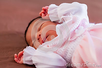 Cute two weeks old newborn baby girl wearing soft pink knit clothes Stock Photo