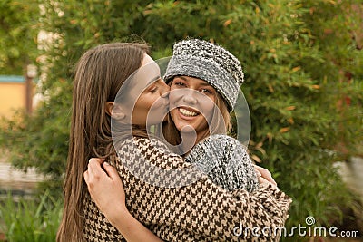 cute two young adult women, head and shoulders shot, kiss cheek, cute outdoors Stock Photo