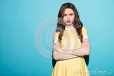 Cute upset girl in dress standing with arms folded Stock Photo