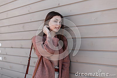 Cute urban young woman fashion model in elegant spring wear posing near vintage building from planks. Comely lovely urban stylish Stock Photo