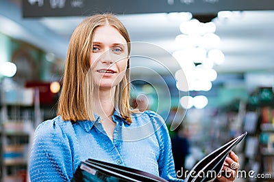 Cute view of woman holding an open paper book, reading bestseller from Stock Photo