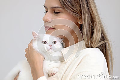 Cute white Persian cat in owner lap hand, happy fluffy pet comfortably being hugged with gently and love feeling by happy owner. Stock Photo