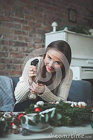 Cute Woman with Electric Glue Gun and Christmas Decor Stock Photo