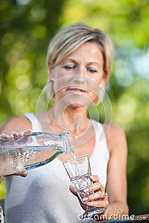 Cute woman pouring water in a glass Stock Photo