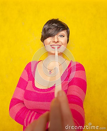 Cute woman with short hair dressed in a pink cozy sweater plays with a large long roll of bubble gum Stock Photo