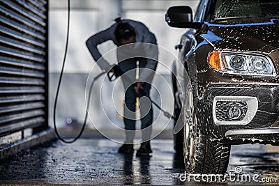 Cute woman washing her car in a manual carwash Stock Photo