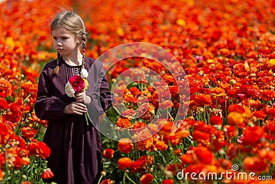 Cute wonderful kid child girl walks in a flowering spring meadow Stock Photo