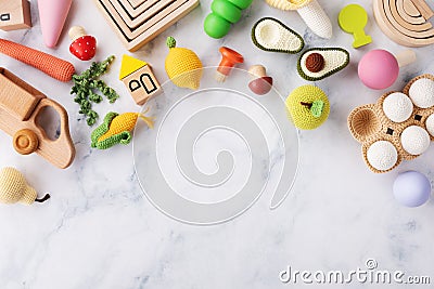 Cute wooden and knitting eco toys for baby activity, motor and sensory development on white table top view. Flat lay Stock Photo