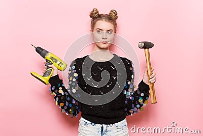 Cute young adult woman holding working tools in hands. Stock Photo