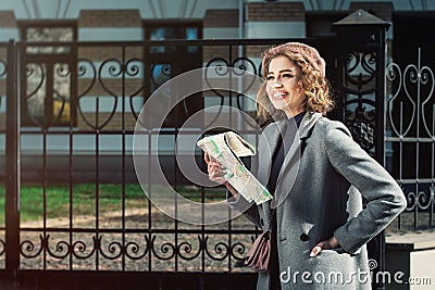 Cute young beautiful curly smiling caucasian travelling woman reading a map Stock Photo