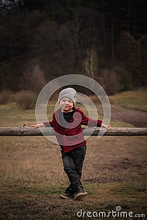 Cute young boy holding a log in the spring garden Stock Photo