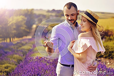 Cute young happy couple in love in a field of lavender flowers. Enjoy a moment of happiness and love in a lavender field. Stock Photo