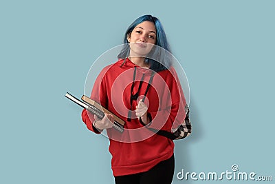 Cute young gilr student with blue hair books and a backpack Stock Photo