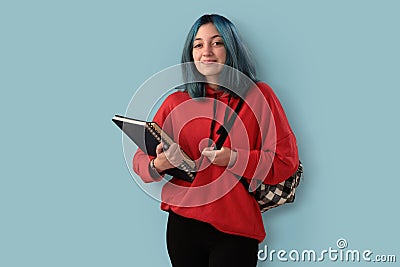 Cute young gilr student with blue hair books and a backpack Stock Photo