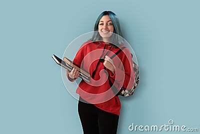 Cute young gilr student with blue hair books and a backpack Stock Photo