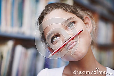 Class clown. A cute young girl balancing her pencil on her lips and pulling a face. Stock Photo