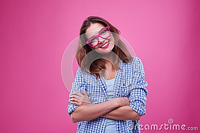 Cute young girl in checked shirt and glasses over pink Stock Photo