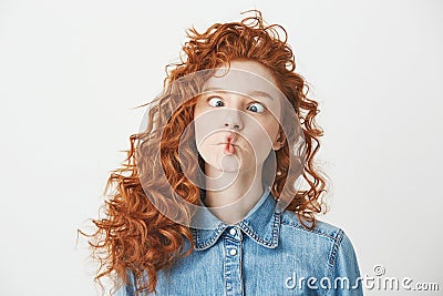 Cute young girl with foxy curly hair making funny face over white background. Copy space. Stock Photo