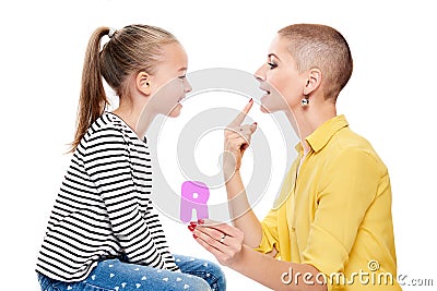 Cute young girl with speech therapist practicing correct pronunciation. Child speech therapy concept on white background. Stock Photo