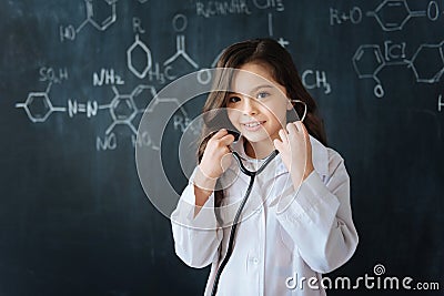 Cute young girl testing stethoscope at school Stock Photo