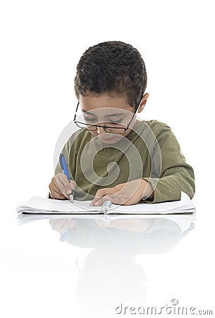 Cute Young Schoolboy Studying with Concentration Stock Photo