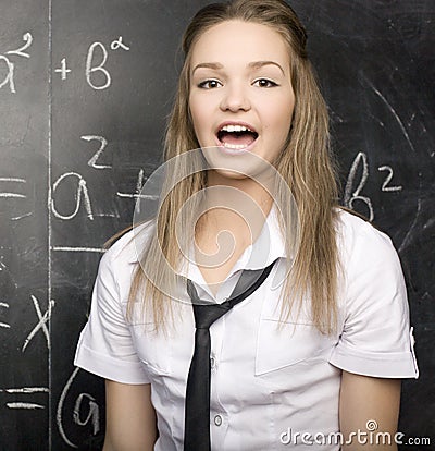 Cute young student near blackboard with copy book calculator pen, copy space Stock Photo