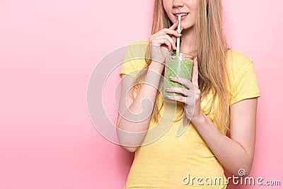 Cute young woman drinking a green gluten-free organic smoothie with straw. Stock Photo