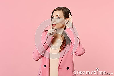 Cute young woman saying hush be quiet with finger on lips shhh gesture eavesdrop with hearing gesture isolated on pastel Stock Photo