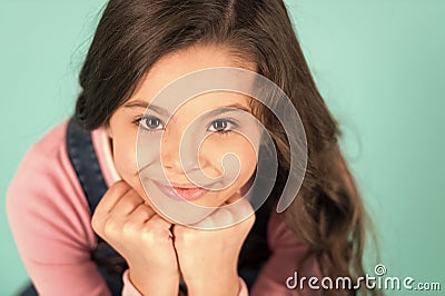 Cuteness overload. Child happy smiling enjoy childhood. Girl adorable smiling happy face lean on fists relaxing. Kid Stock Photo