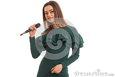 Cutie brunette woman in elegnat green dress with microphone Stock Photo