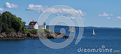 Cutler Island Lighthouse with sailboats floating by. Maine coast Camden Stock Photo