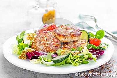 Cutlets and fresh vegetable salad on white plate. Fried meatballs with vegetable salad Stock Photo