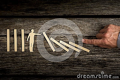 Cutout of a man holding up fallen dominoes as human hand pushes Stock Photo