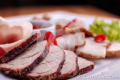 Cutting bacon, sausage, prosciutto and cured meat on a celebratory table Stock Photo