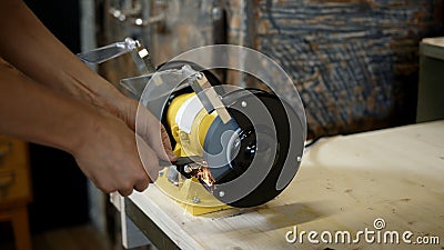 Electric sharpener and blade close up, hands cutting knife Stock Photo