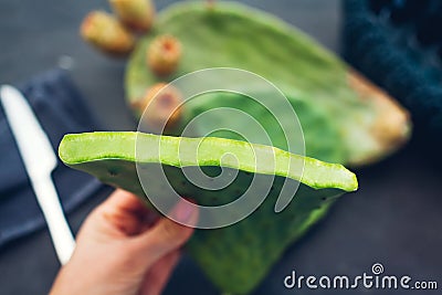 Cutting cactus leaves with prickly pear or cactus fruit. Exotic healthy food on grey background. Top view Stock Photo