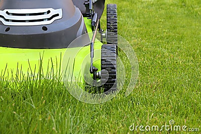 Cutting the grass with electric lawn mower Stock Photo