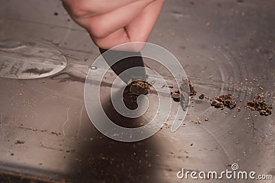 Cutting industrial block of dark chocolate with knife Stock Photo
