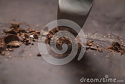 Cutting industrial block of dark chocolate with knife Stock Photo