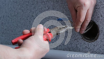 Cutting live wires with wire cutters Stock Photo