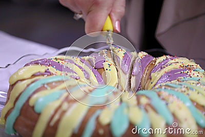 Cutting Into a Mardi Gras King Cake Stock Photo