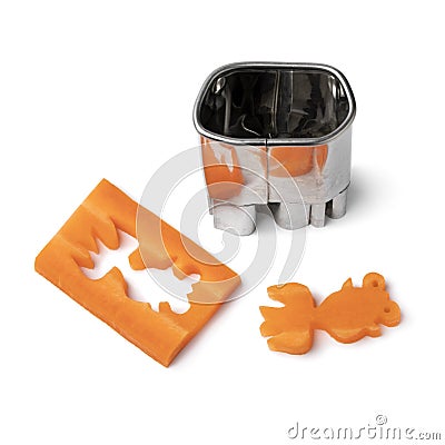Cutting out a goldfish from fresh raw sweet winter carrot with a mold on white background Stock Photo